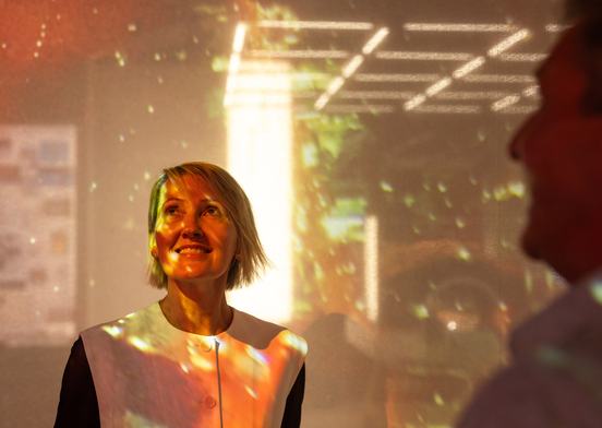 Woman standing under multicoloured light. Image credit: Charlie Kinross