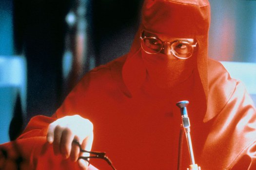 Jeremy Irons in a red surgical gown in a still from 'Dead Ringers' (1988)