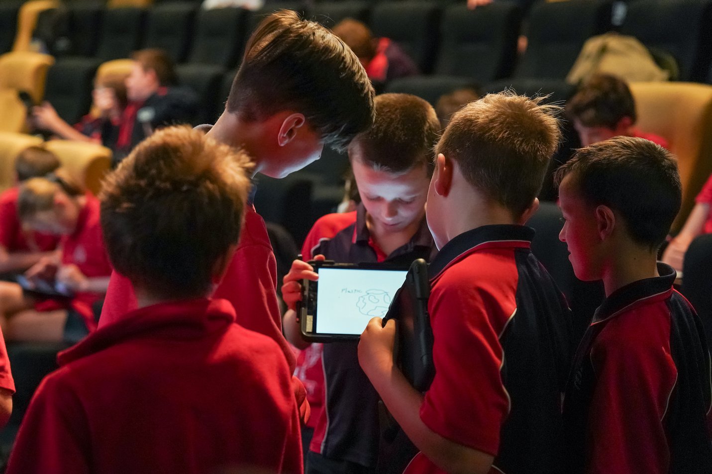Students in a group admire a digital ad on an iPad Students in a group admire a digital ad on an iPad