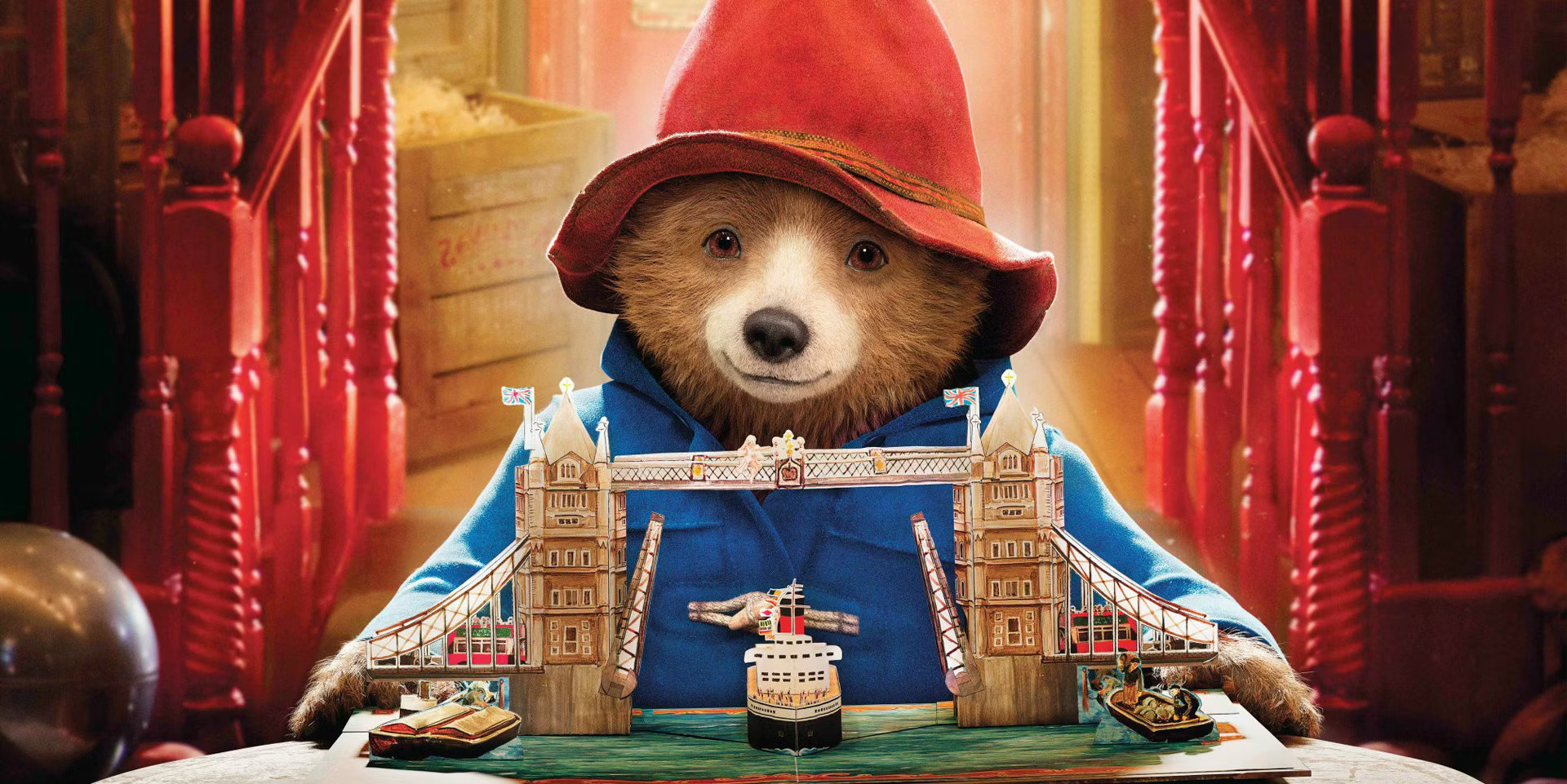 The character, Paddington bear, holding a pop up book of London, from the film Paddington 2.