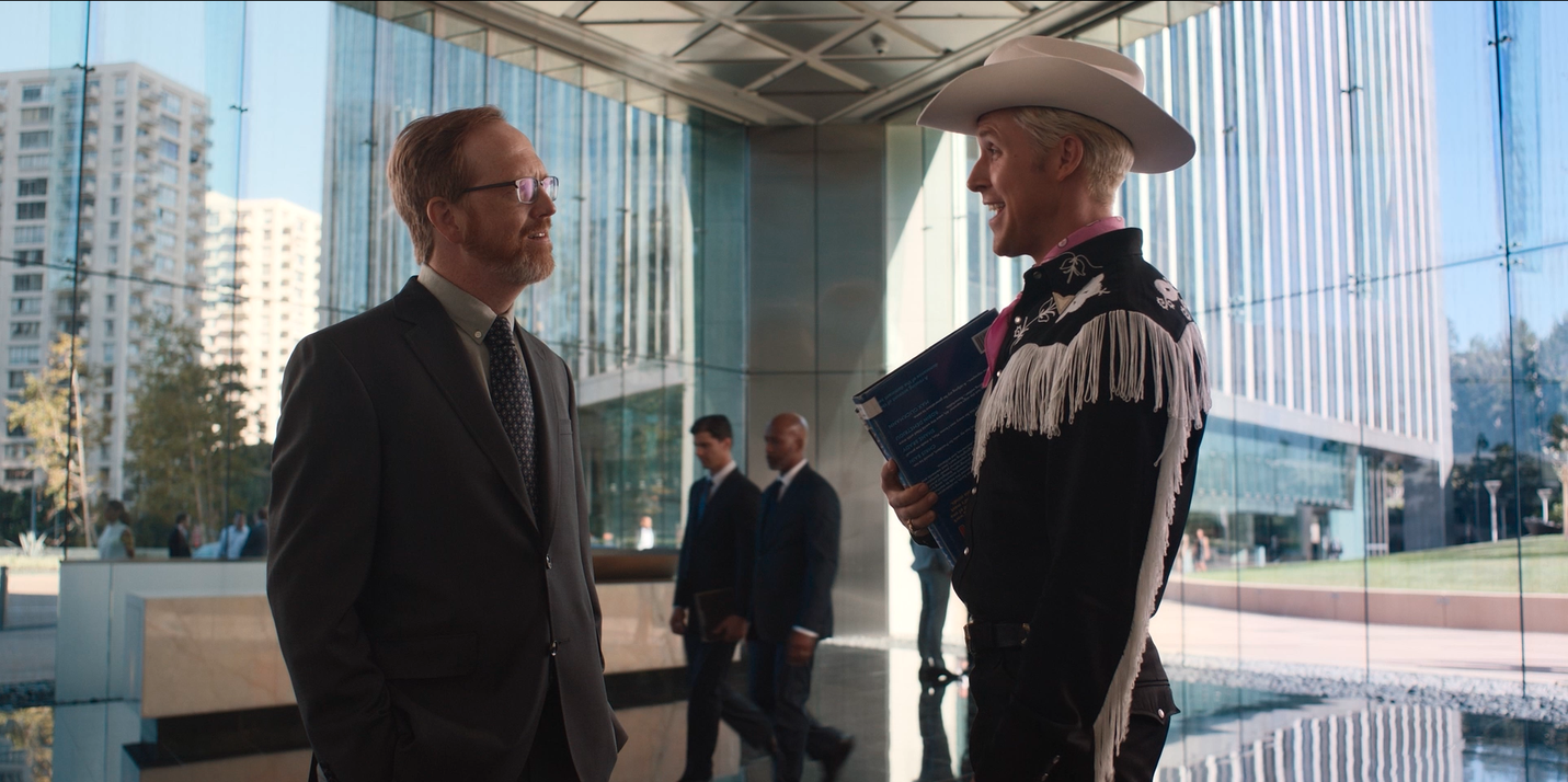 Ken played by Ryan Gosling talks confidently to business man in large office building