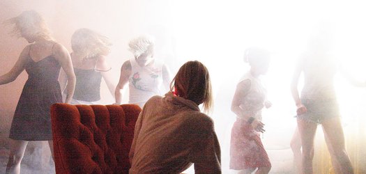 Five actresses dance behind Laura Dern's chair in a hazy room - still from 'Inland Empire' (2006)