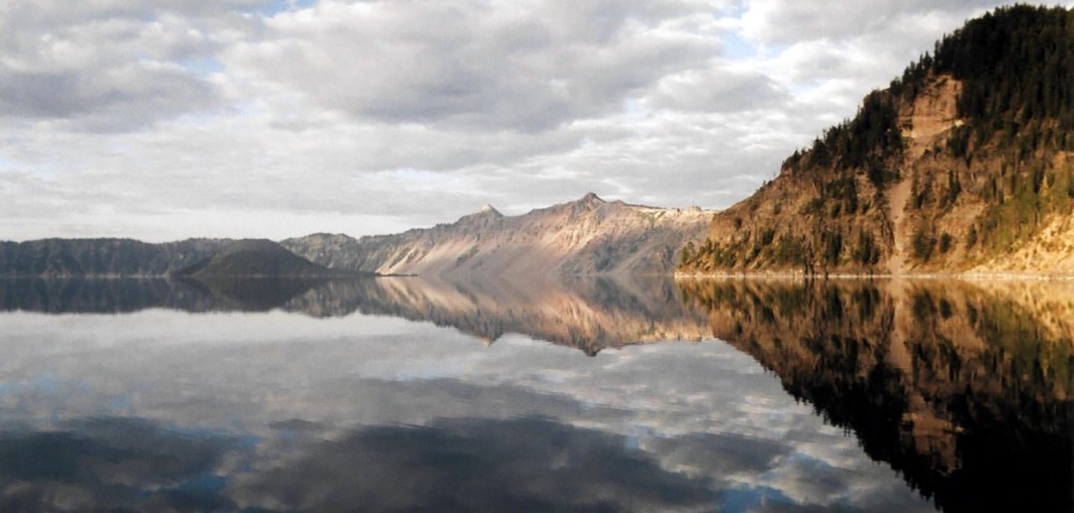 Mountains and hills mirrored in a lake. Still from '13 Lakes' (2004)