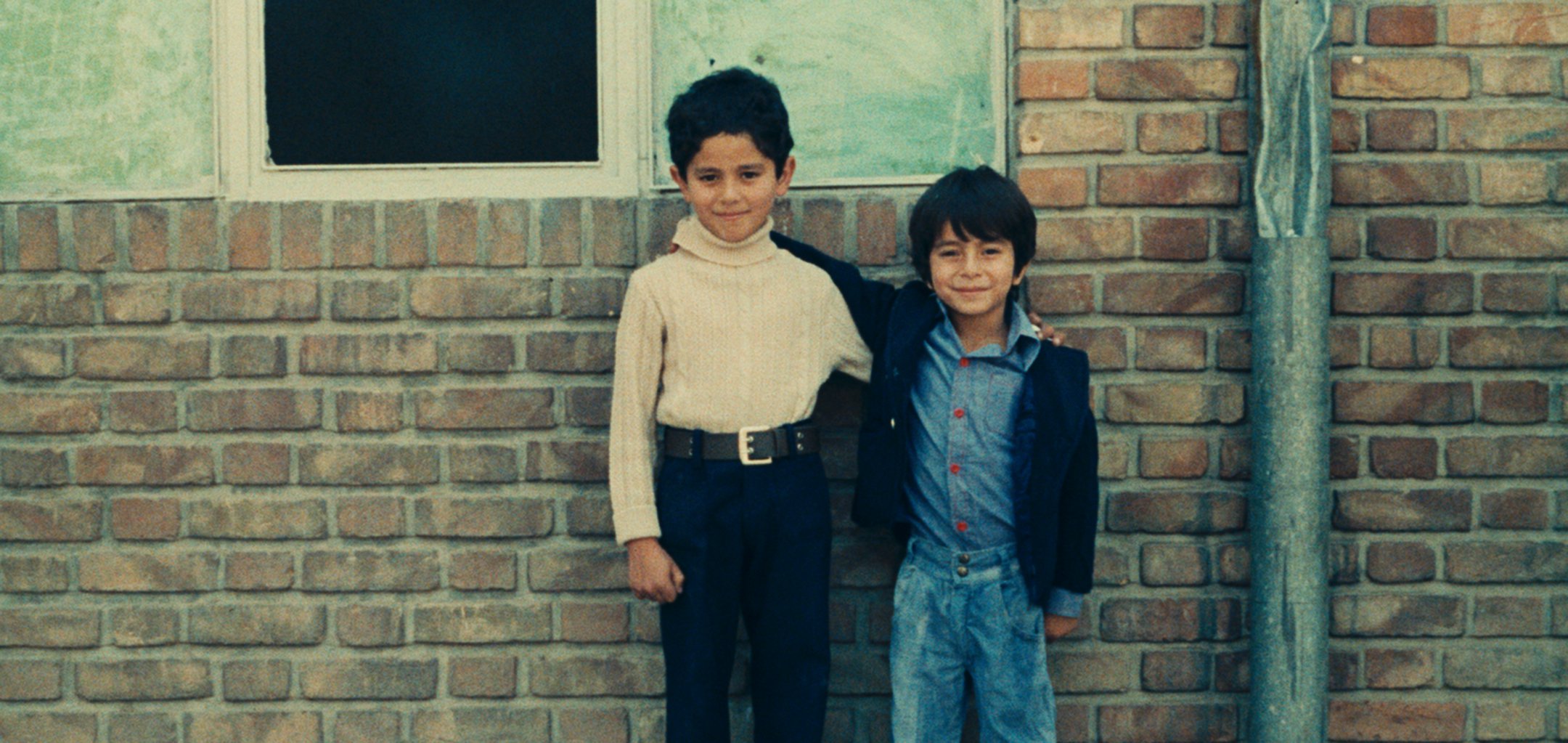 Still of two boys standing against a brick wall in a still from 'Two Solutions For One Problem' (1975) (c) Kanoon