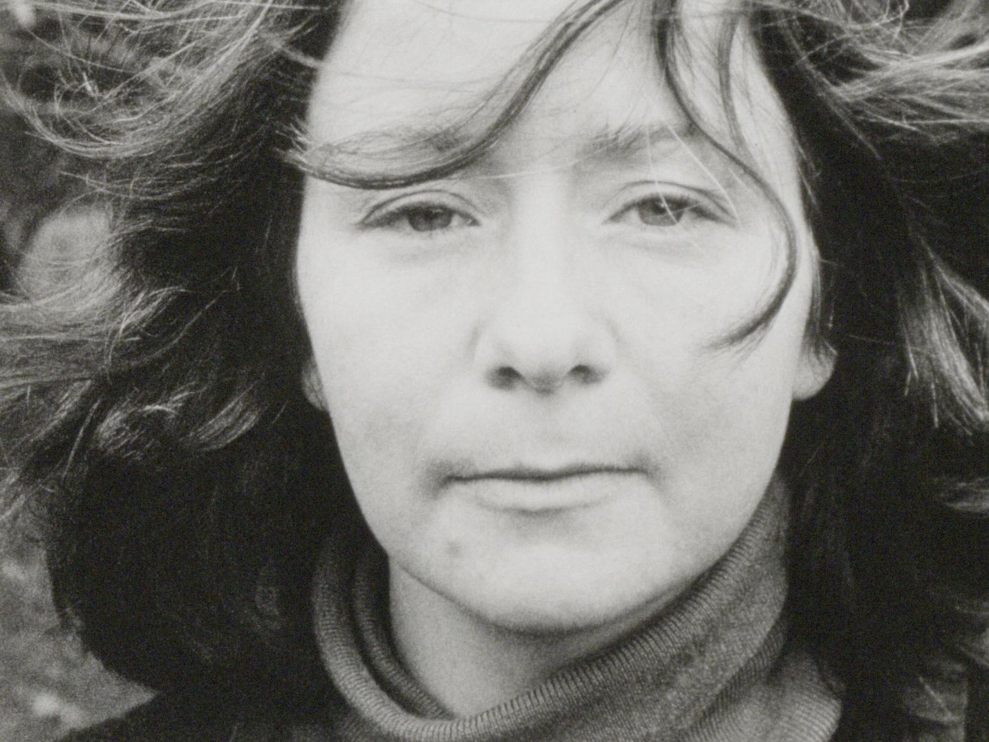 Still from 'Faces' (1976) by Sue Ford. A closeup of a woman with shoulder length dark hair