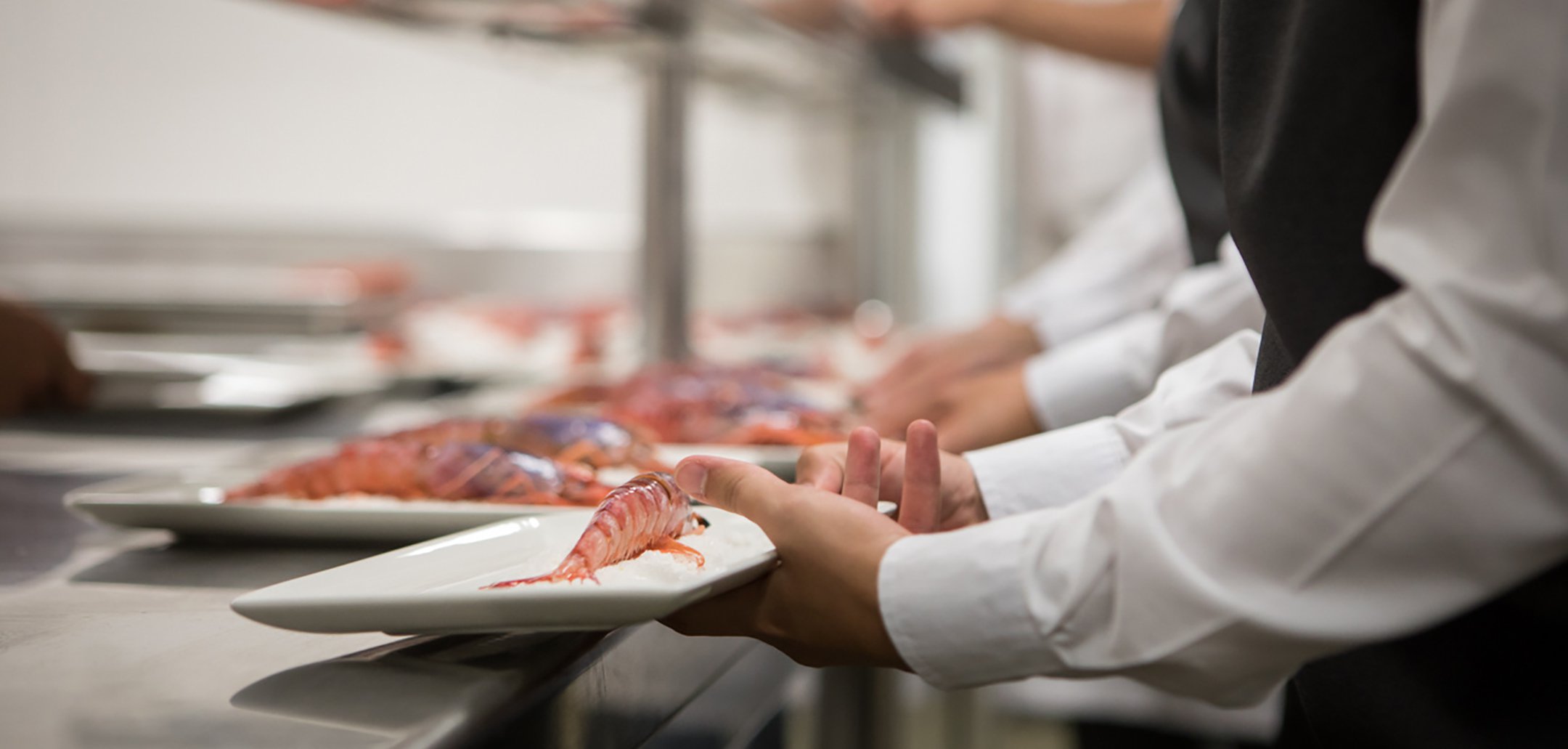 A close up of a plated prawn dish held by a chef in a still from 'A God in Every Lentil' (2018)