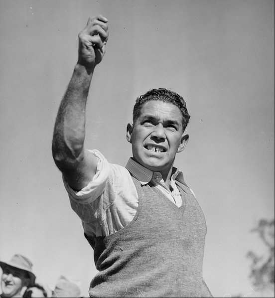 Bill Onus holding his arm to the sky