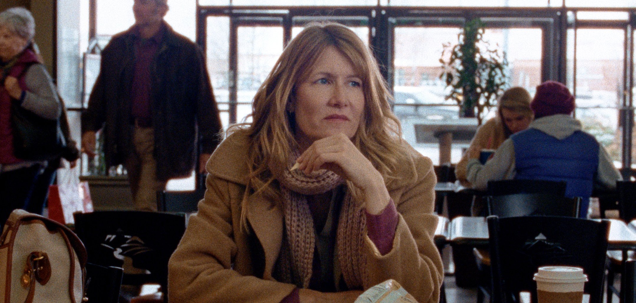 Laura Dern sitting in a cafe in a still from 'Certain Women' (2016)