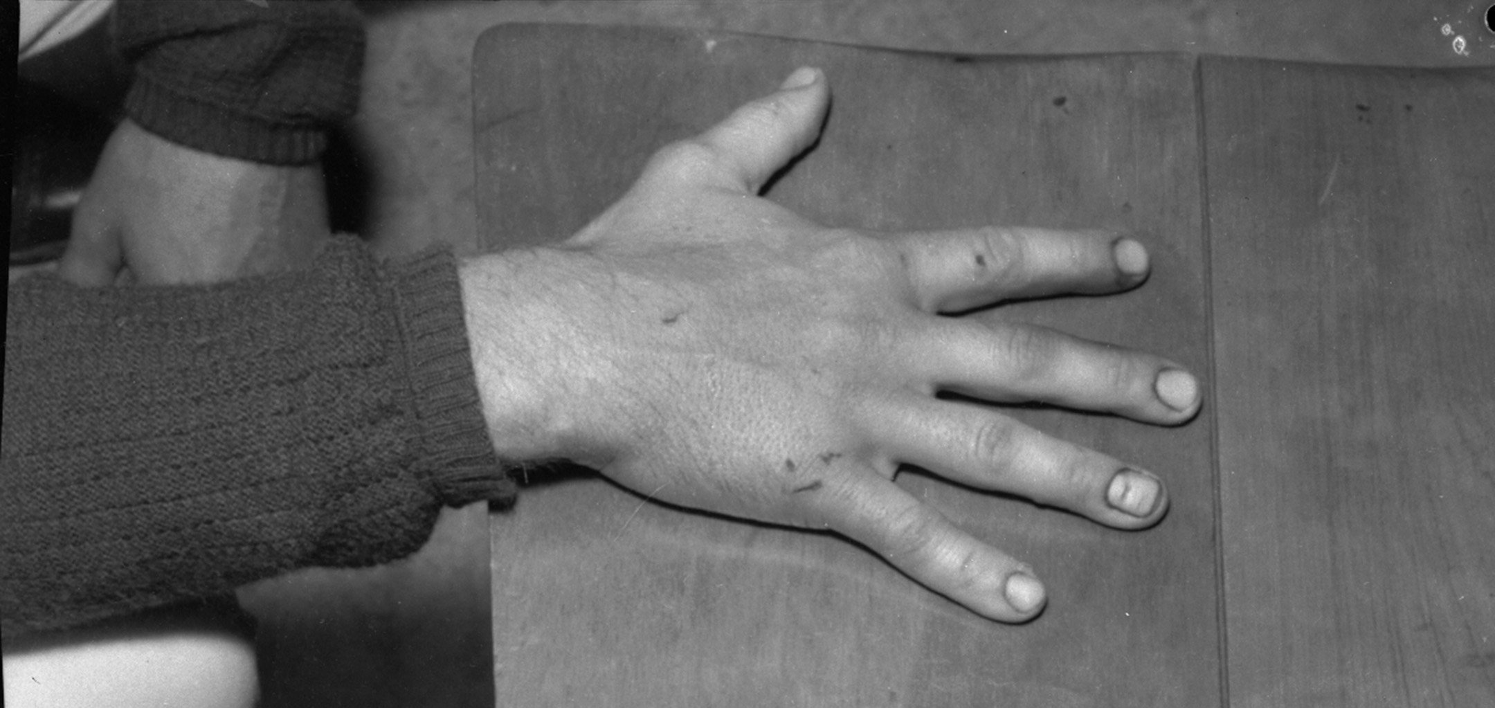 Closeup of hand - a still from Ross Gibson - head_phone_film_poems