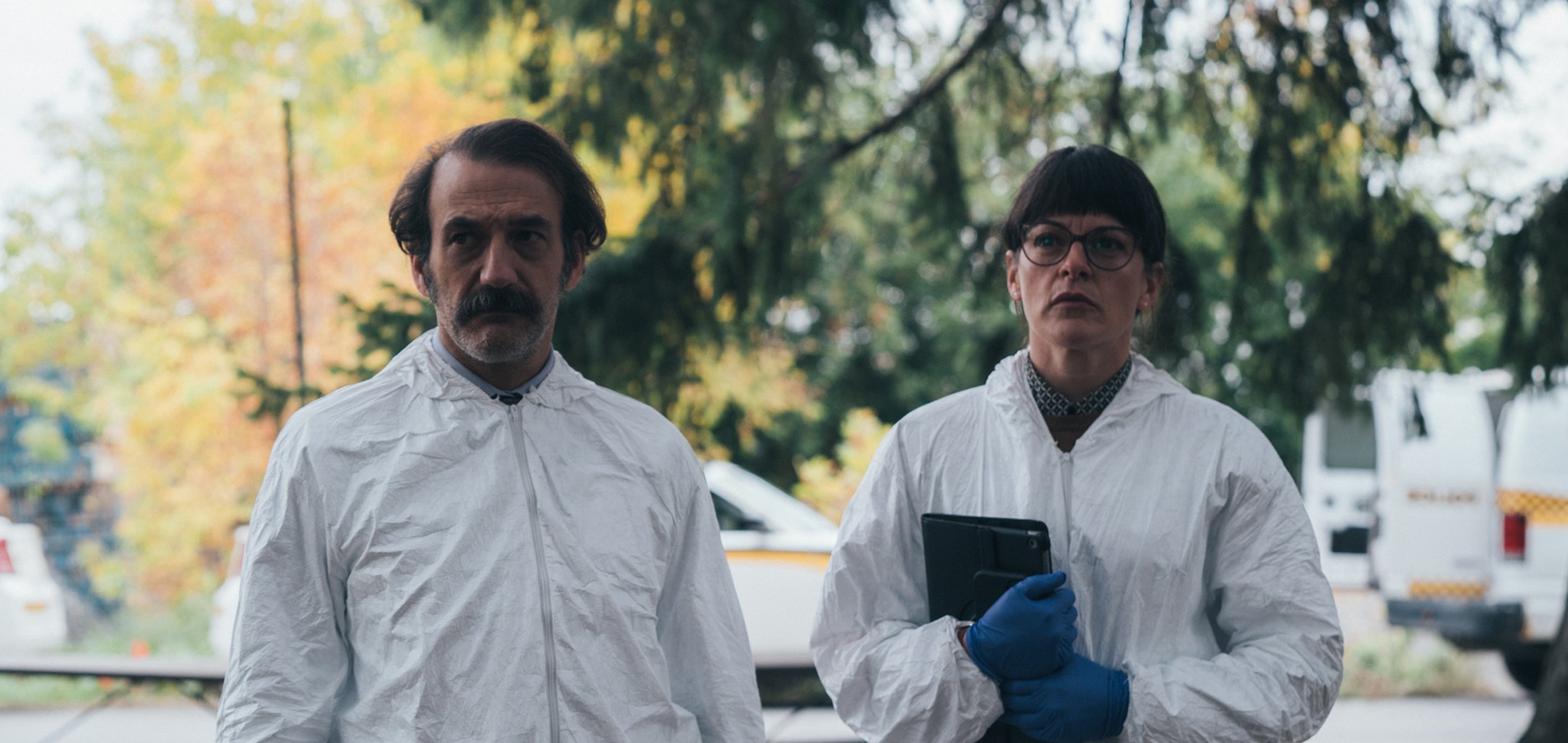 Two people in crime scene clothing in a still from 'Dark Soul '(2021) Encore International