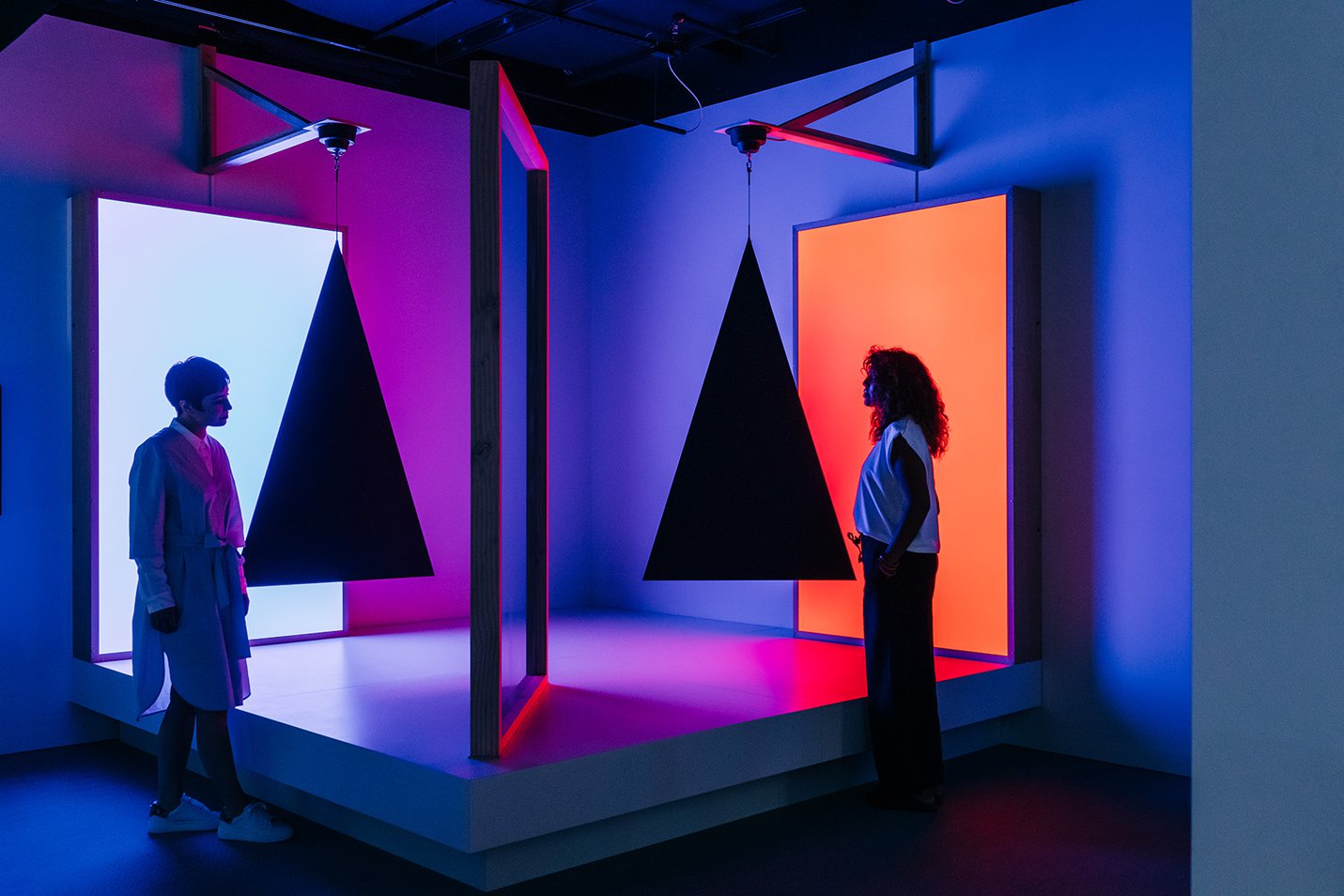 Visitors looking at Pepper's ghost effect, triangles, cyan and red , Taree Mackenzie, 2018 photograph by Gareth Sobey