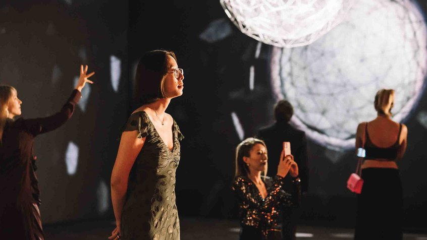 A group of women admiring Olafur Elaisson's Stardust Particle installation at Light: Works from Tate's Collection exhibition at ACMI.