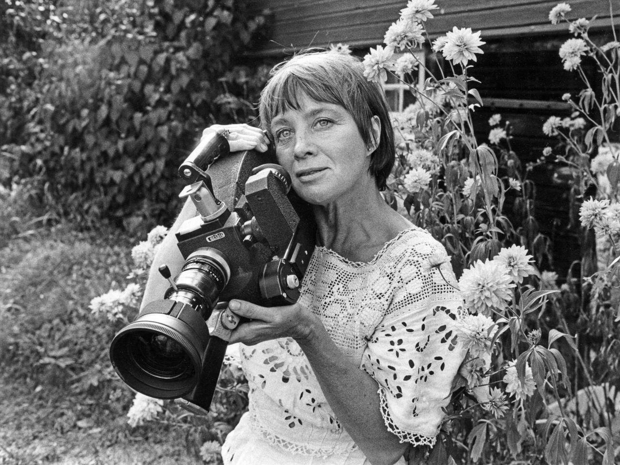 Mai Zetterling in later years posing with a camera in her garden
