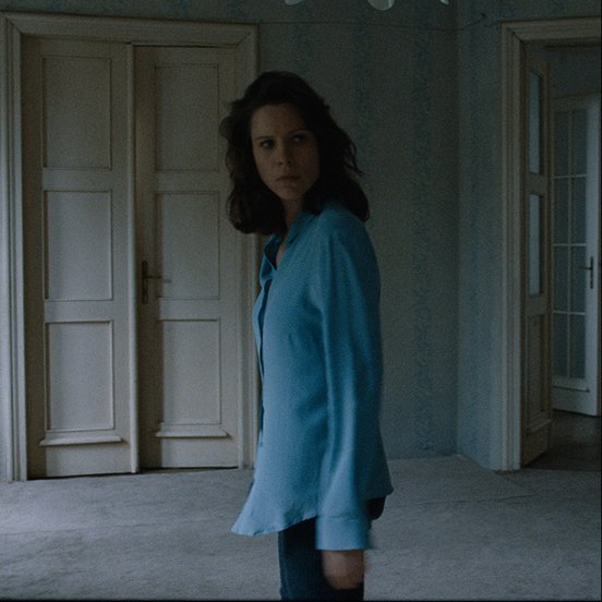 Natasa Stork as Vizy Márta in a blue shirt in a still from 'Preparations to Be Together for an Unknown Period of Time' (2020)