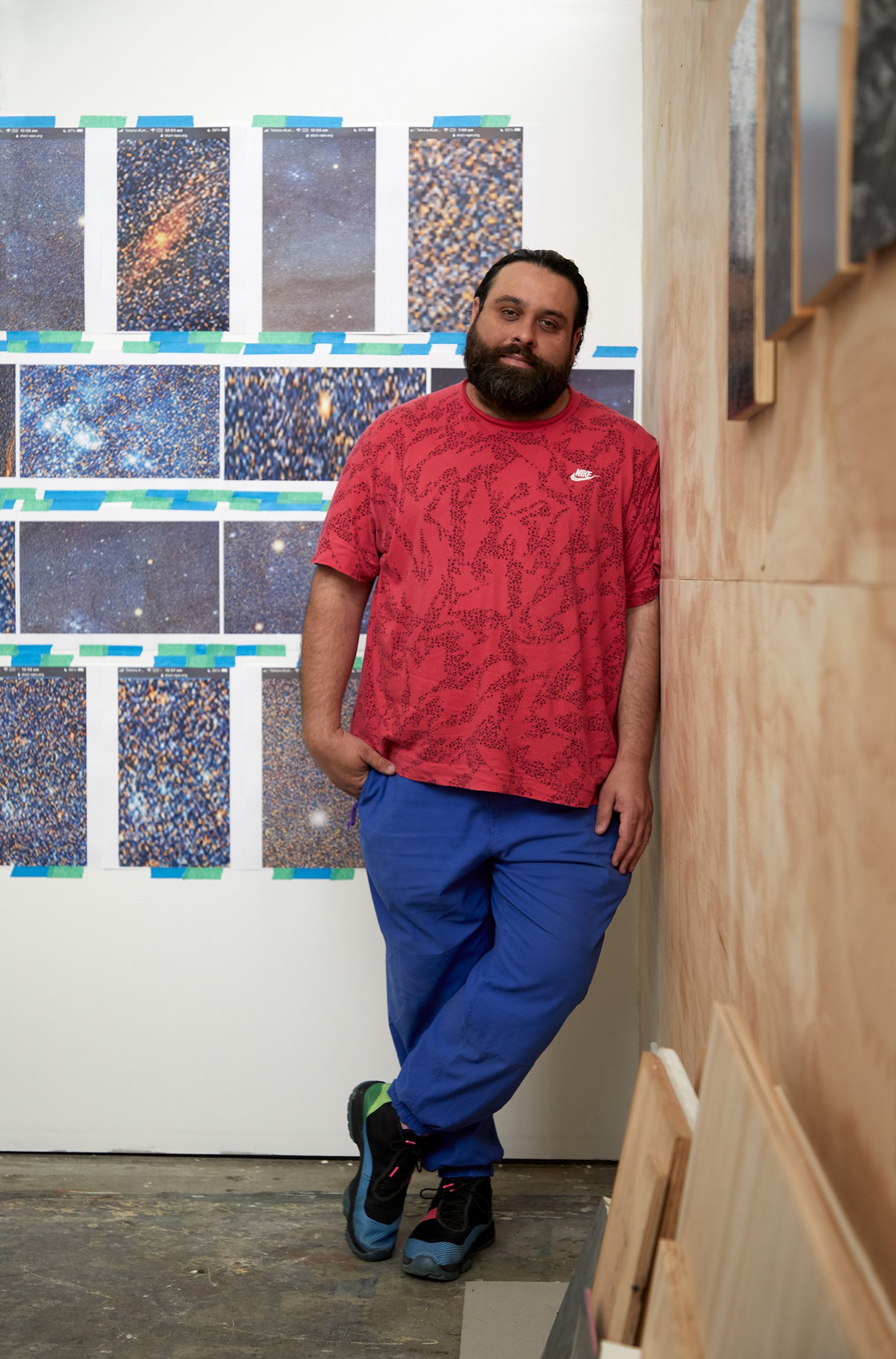 Rohan Schwartz standing and leaning against a wall in a studio
