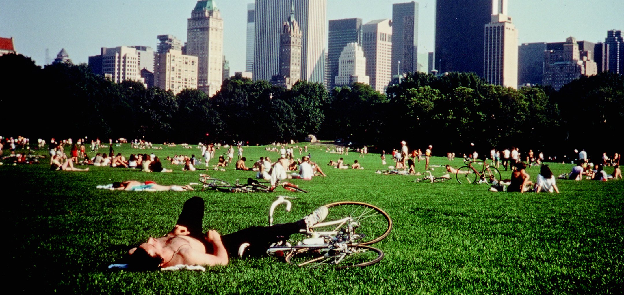 People lying in the grass in Central Park in a still from Frederick Wiseman;s 'Central Park' (1989) Zipporah Films, Inc.