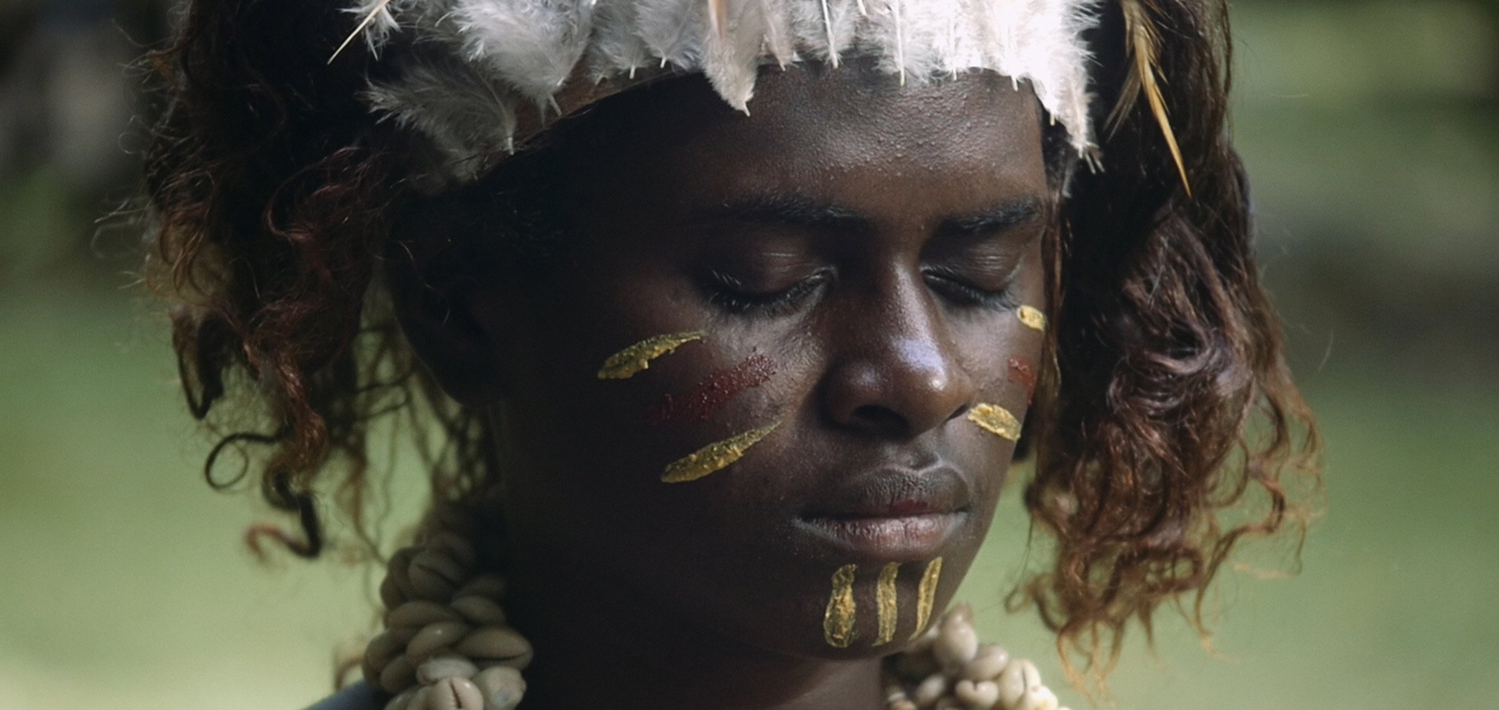 Still from Ophir - closeup of Bougainville woman with ritual face paint, eyes closed