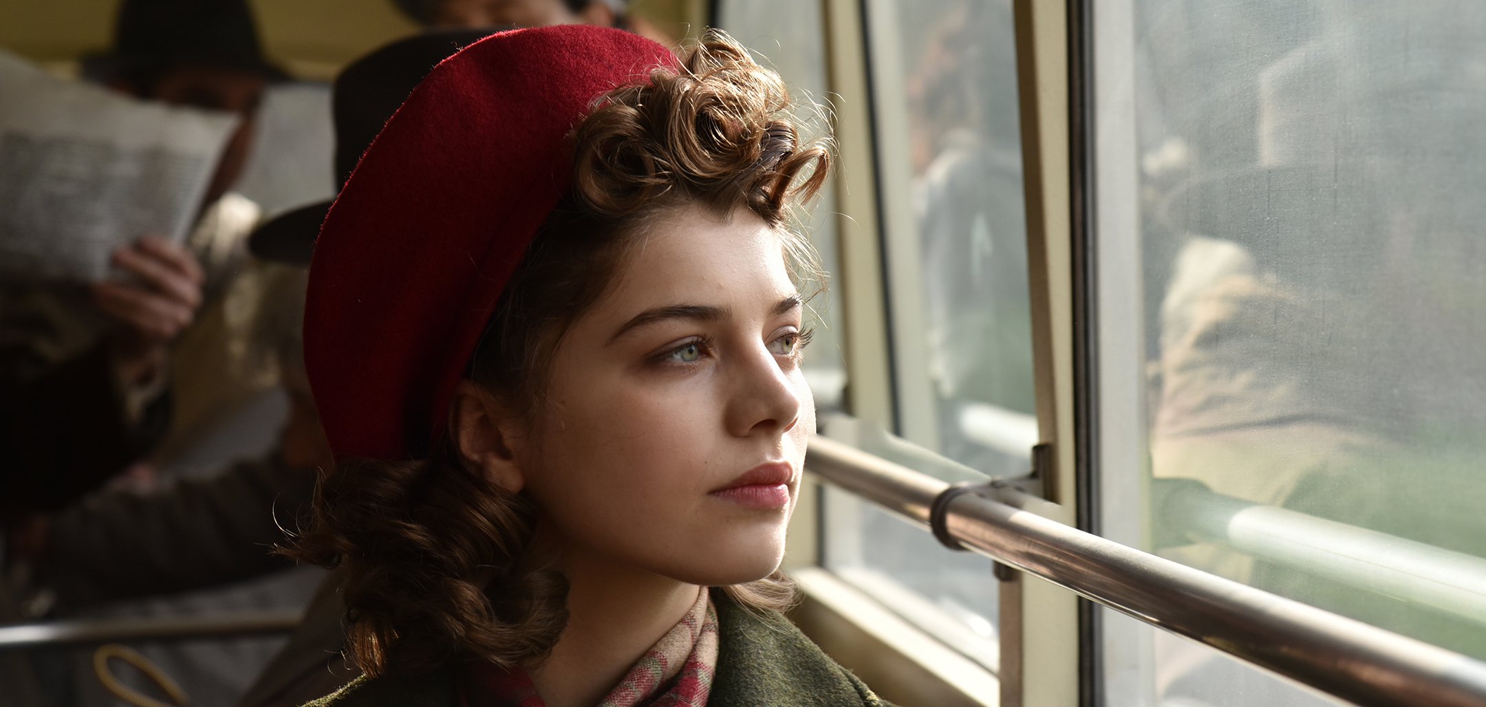 A closeup shot of Klara (played by Abigél Szőke) looking out a train window in a still from 'Those Who Remained' (2019).