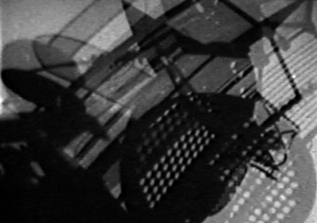 A black and white abstract image of overlapping, mechanical shapes