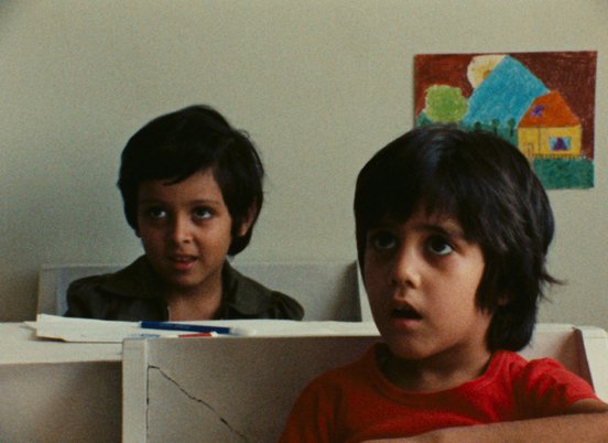 Two young boys attentively listening in a classrooom in a still from 'So Can I' (1975)