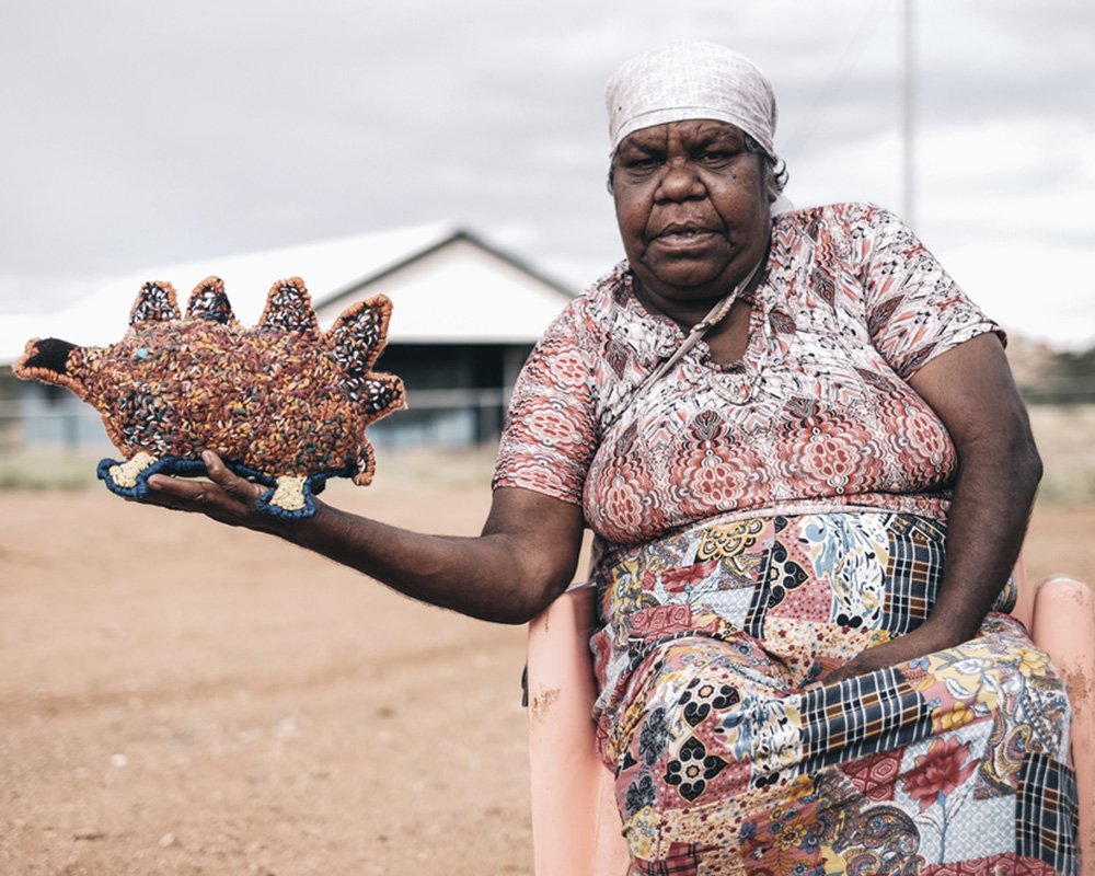 Marlene Rubuntja holding an echidna she stitched. Photo courtesy of Yarrenyty Arltere Artists